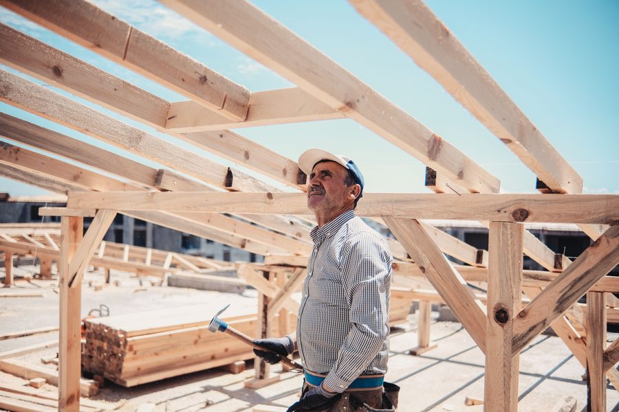 Charpentier sous une charpente en bois